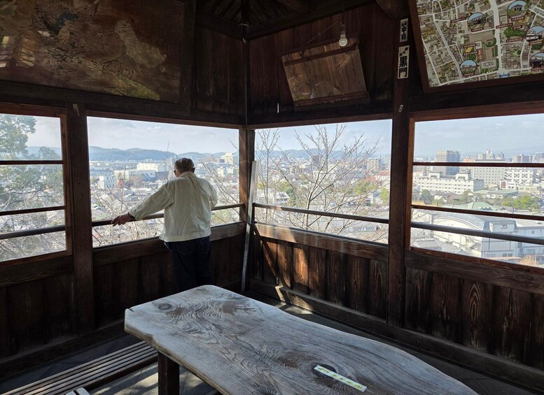 A man painting a wooden structure with a map in the background. 3