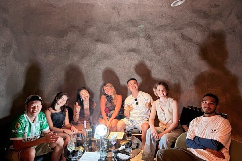 A group of people sitting around a table in a cave-like setting. 1
