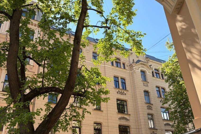 A multi-story building with classical architecture, surrounded by trees. 4