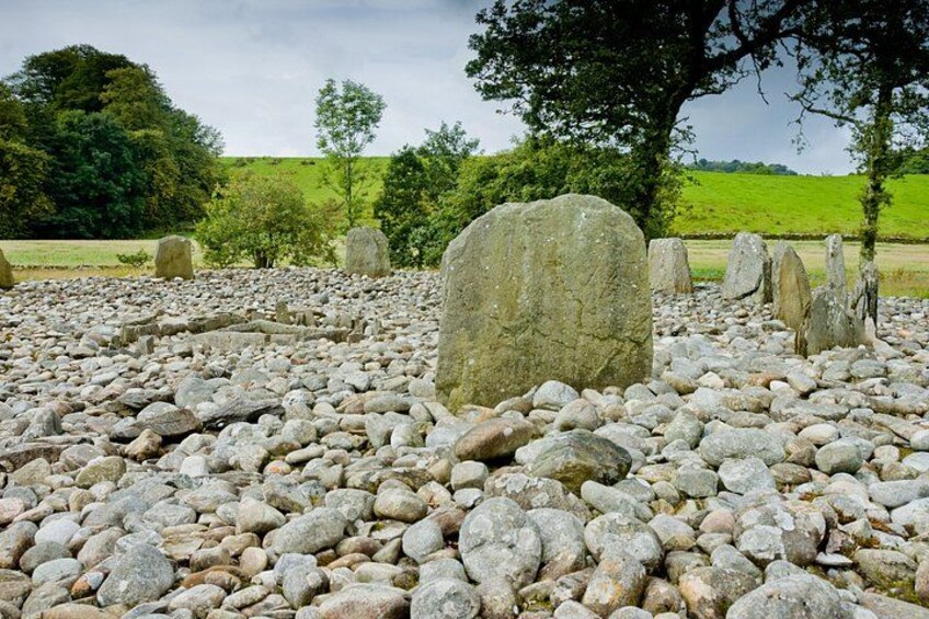 A stone circle with large standing stones in a grassy field. 3