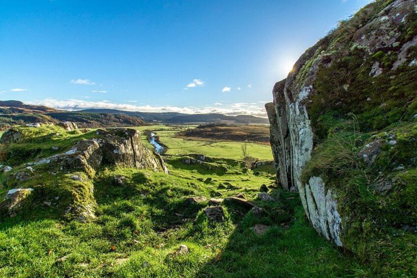 A mountainous landscape with grassy valleys and rocky outcrops. 1
