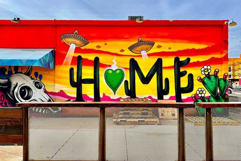 A colorful mural with the word 'HOME' and cacti. 4
