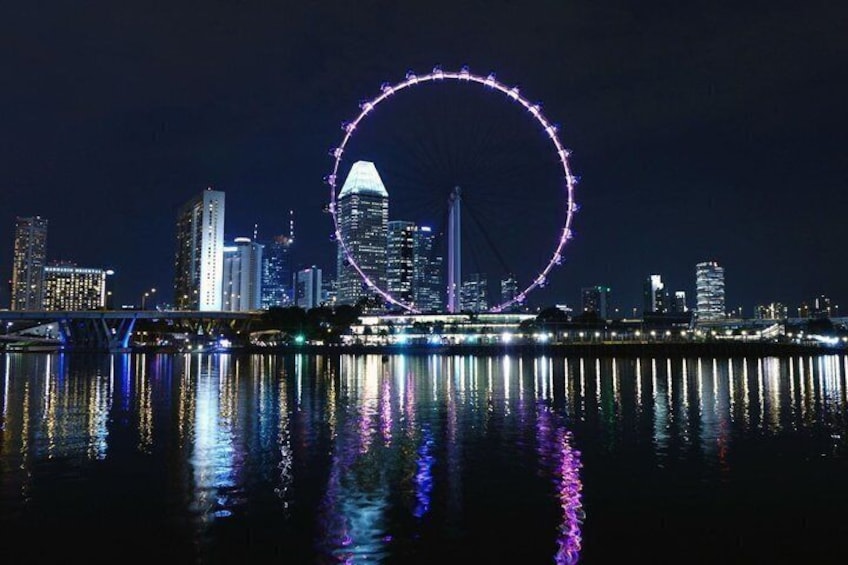 A city skyline with a prominent Ferris wheel and a bridge reflecting in the water. 3