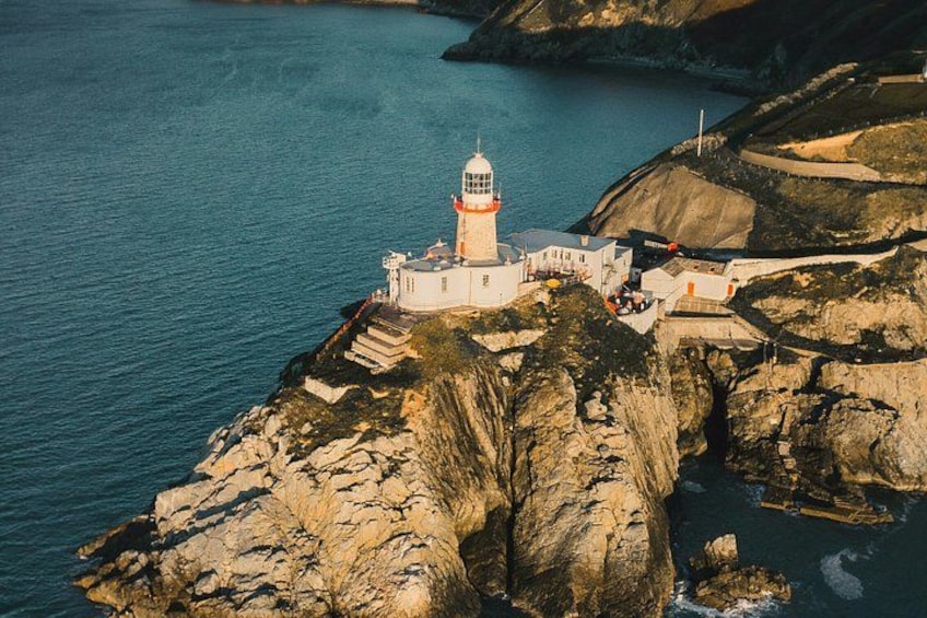 A lighthouse on a rocky coastline with clear blue water. 1
