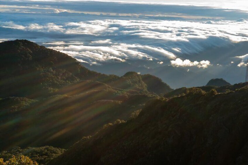 A mountainous landscape with a layer of clouds below. 3