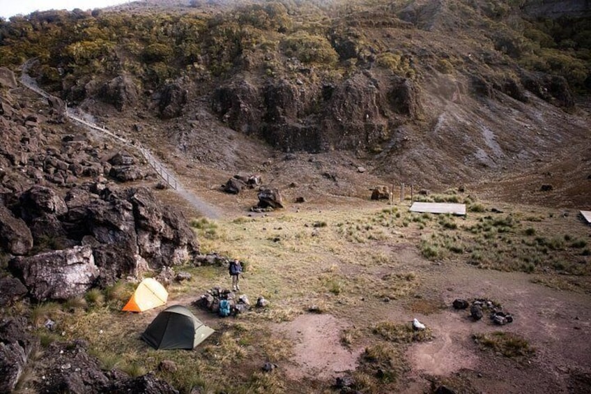 A mountainous camping area with tents and a rocky terrain. 5