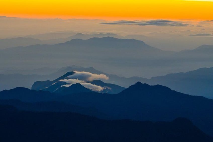 A mountain range with a prominent peak, clouds, and a sunset. 2