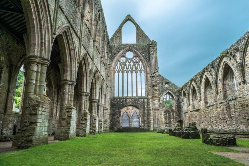An ancient Gothic church with arched windows and a central rose window. 2