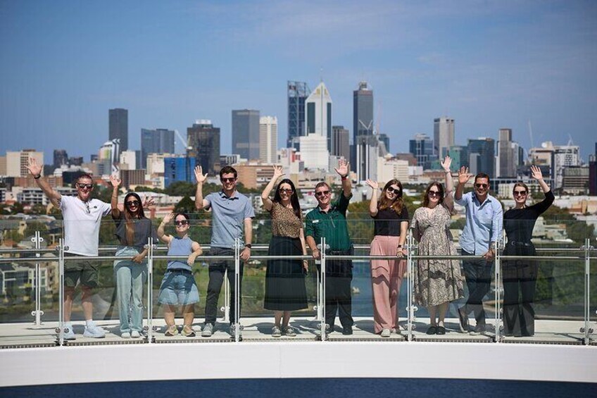 A group of people on a rooftop with a city skyline in the background. 1
