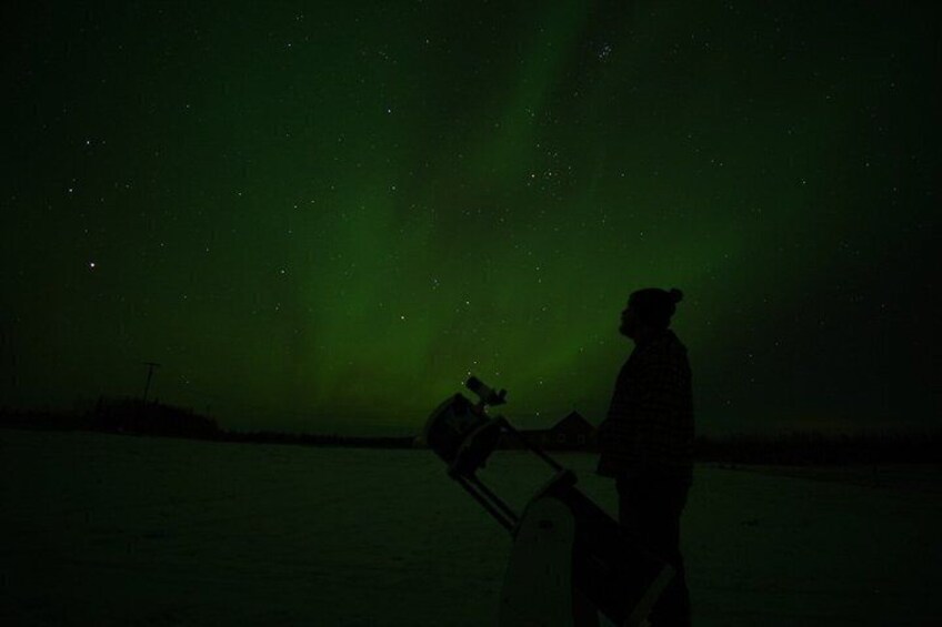 A person with a telescope against a night sky with visible stars. 1