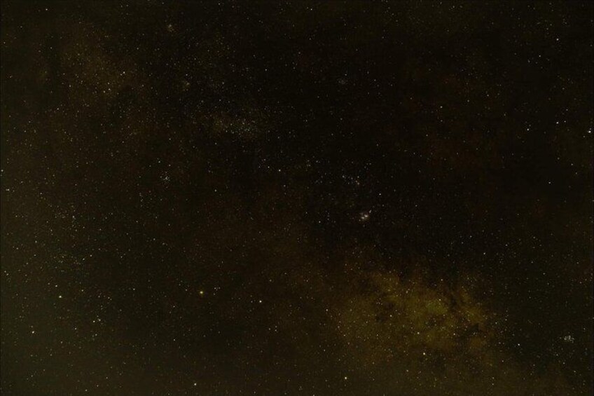 A starry night sky with visible stars and a faintly visible galaxy. 2