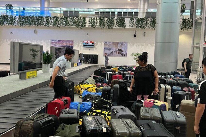 A luggage carousel at an airport with various suitcases and bags. 5