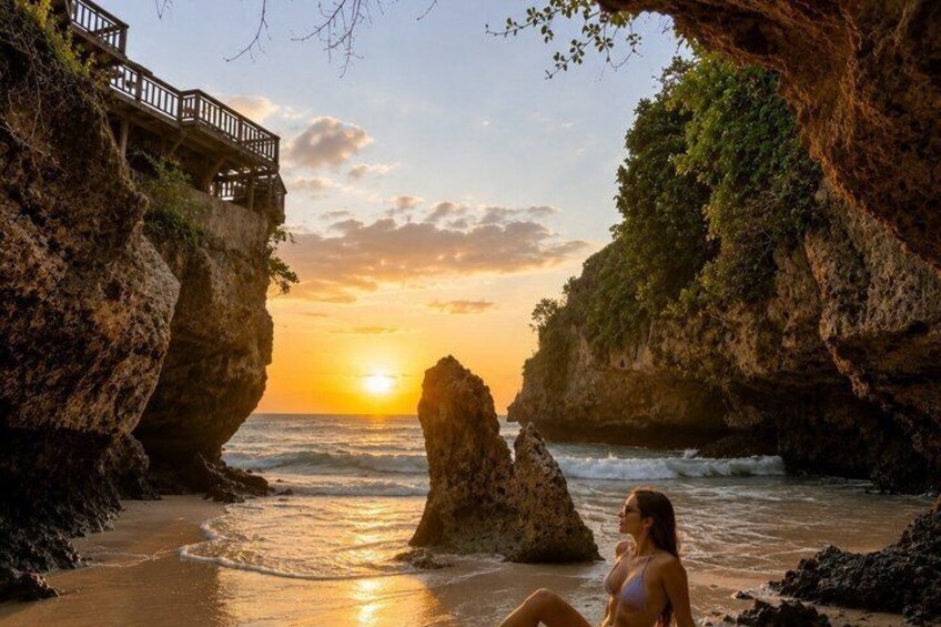 A sunset at a rocky beach with a wooden walkway and a woman sitting on the sand. 3