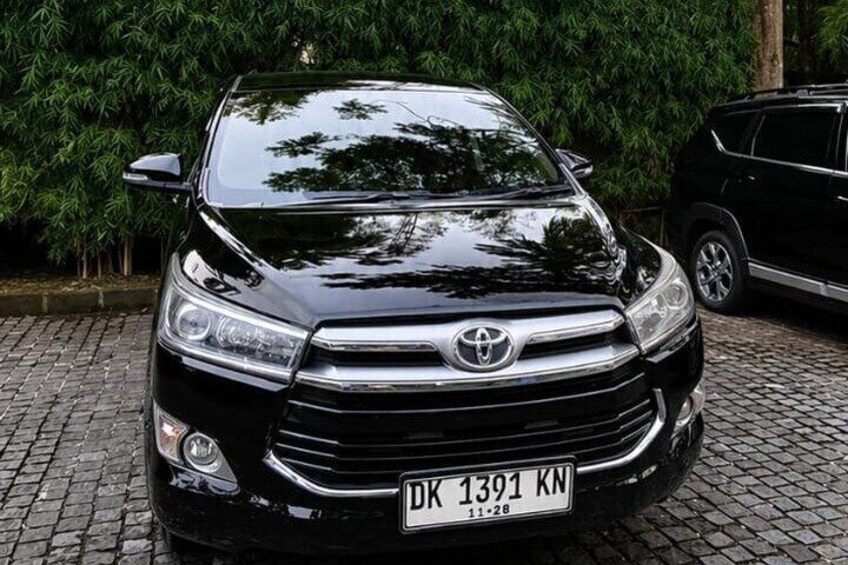 A black Toyota SUV with a visible license plate DK 1391 KN parked on a cobblestone surface. 1