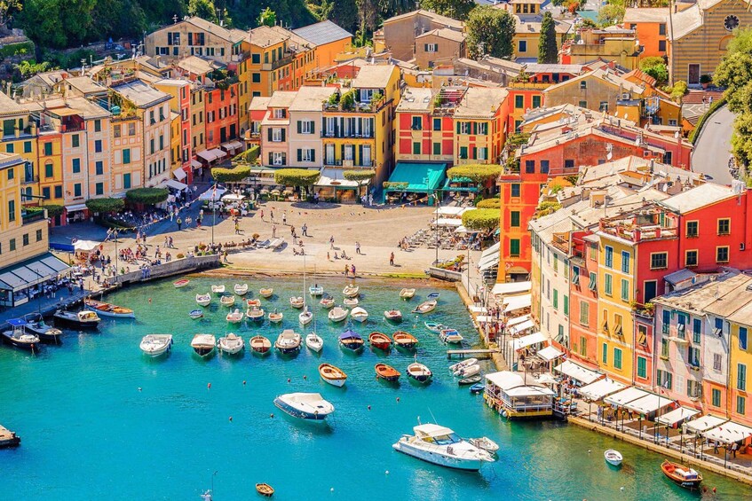 A coastal town with colorful buildings, a marina with boats, and a sandy beach. 3