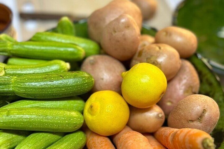 A variety of fresh vegetables including zucchini, carrots, potatoes, and lemons. 4