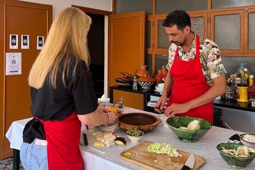 A person preparing food in a kitchen with a cutting board, bowls, and various kitchen utensils. 3