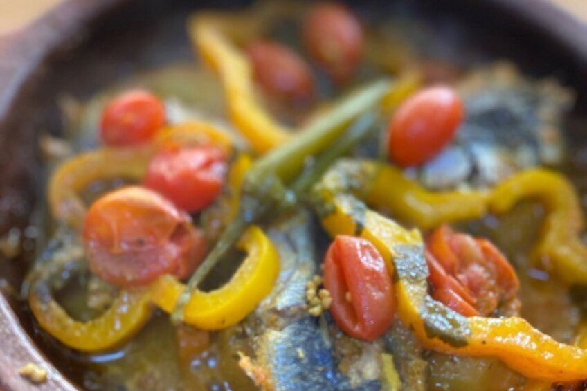 A close-up of a dish with sliced tomatoes, green beans, and yellow bell peppers. 2