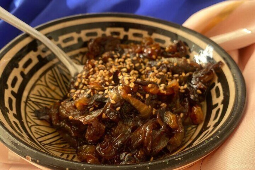 A dish of braised meat garnished with sesame seeds. 4
