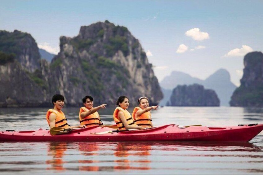 A group of people in a red boat on calm water with mountainous landscape in the background. 1
