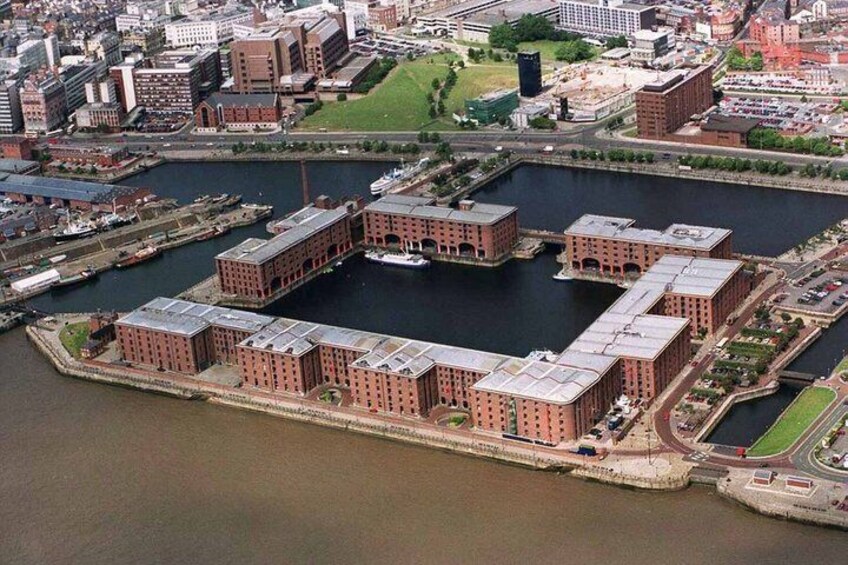 A large industrial complex with multiple brick buildings and a central water body. 5