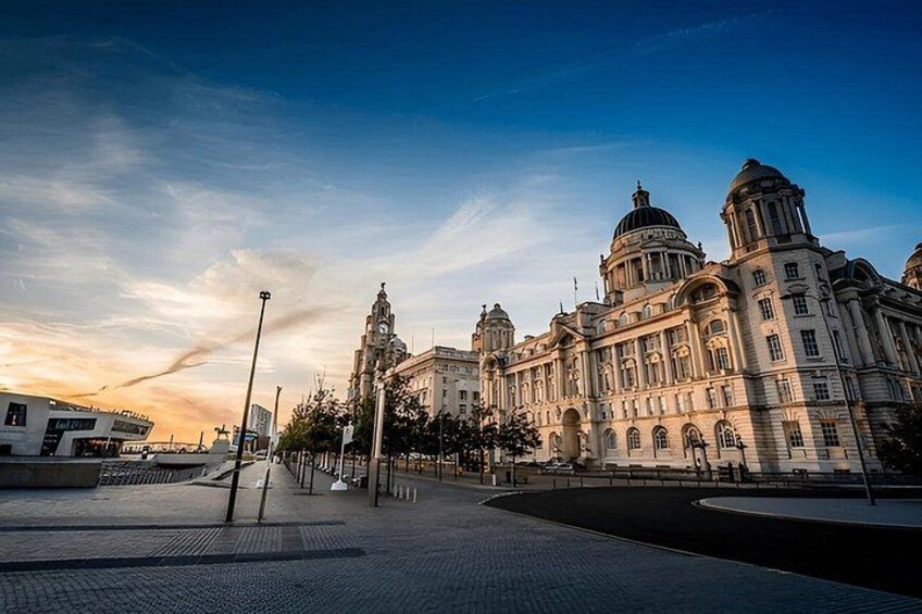 A historic building with domed architecture, a paved plaza, and a clear sky. 3