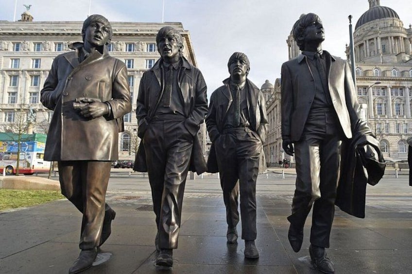 A statue of four men walking in a line. 1