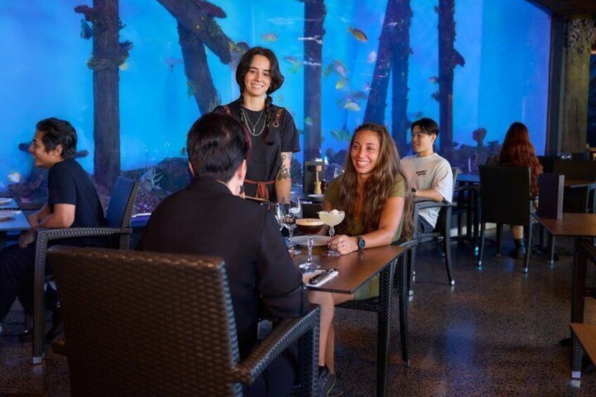 A restaurant with an aquarium backdrop. 3