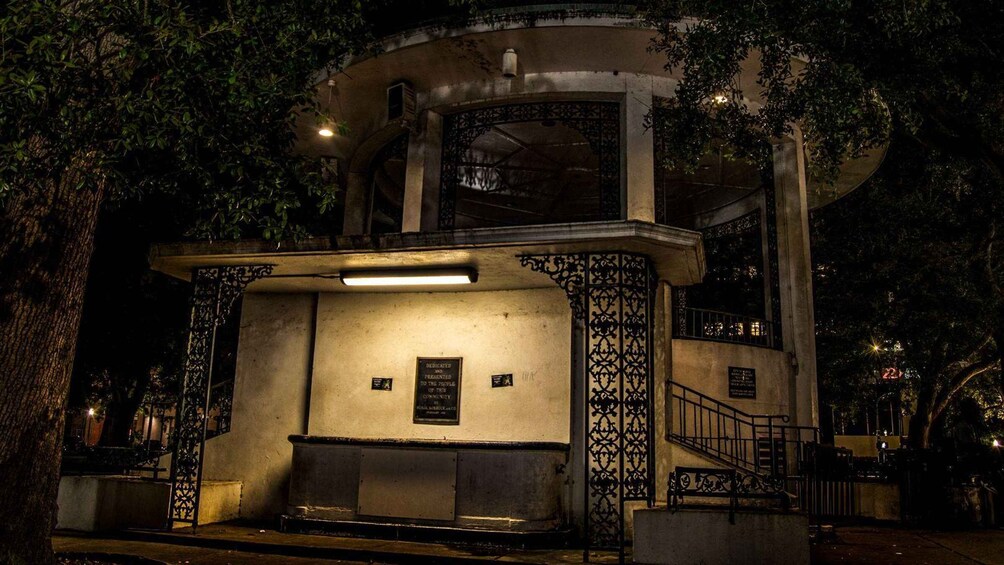 A historic building with ornate ironwork and a plaque dedicated to the community. 3