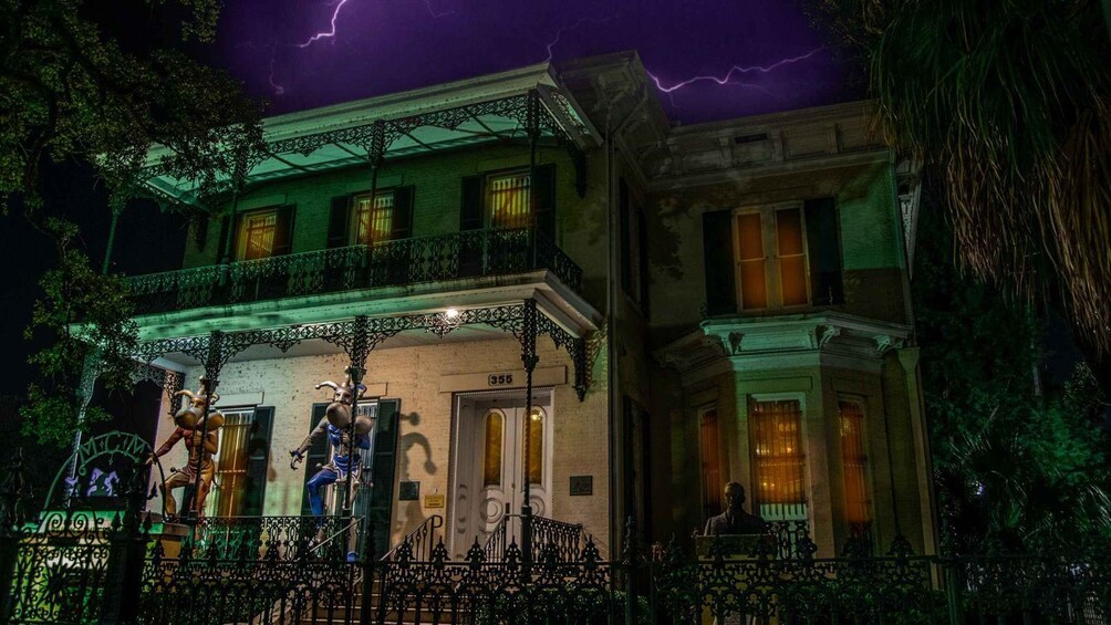 A two-story building with ornate balconies and a stormy sky. 1