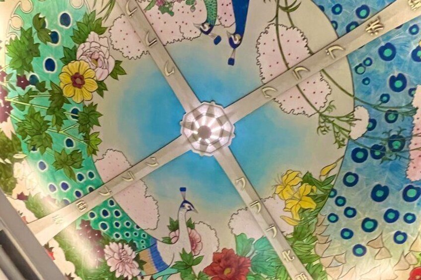 A ceiling with a floral pattern and a central light fixture. 1