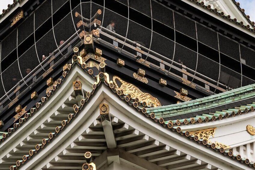 A traditional Japanese building with ornate golden decorations and a green roof. 5