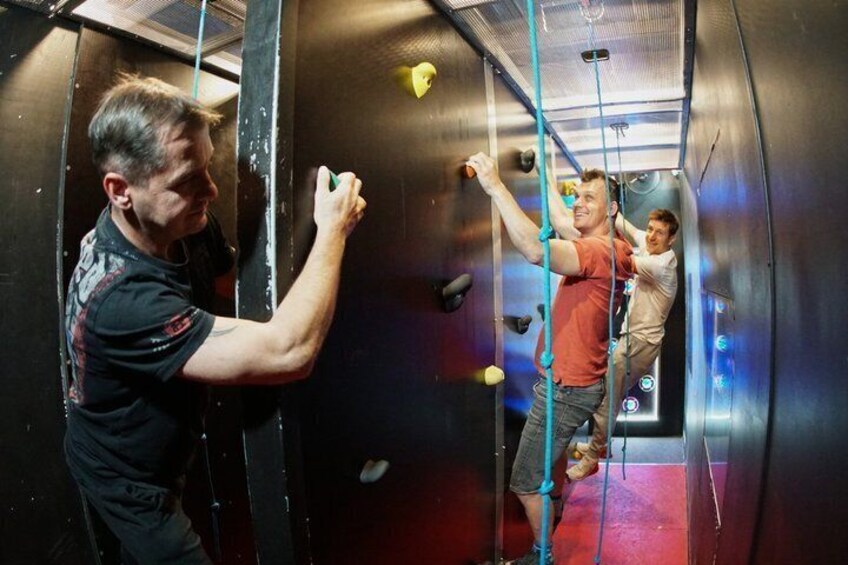 An indoor climbing wall with ropes and holds. 4