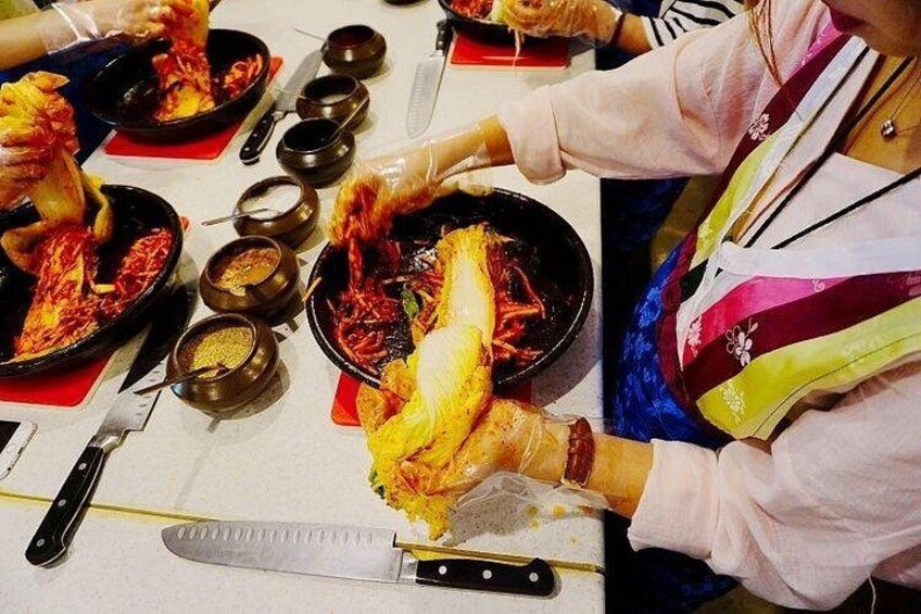 A person preparing food, with a table full of dishes and utensils. 2