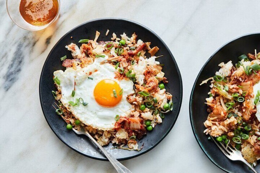 Two plates of fried rice with egg and green onions. 1