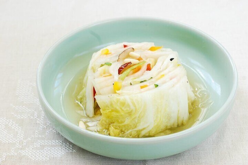 A bowl of fish soup with vegetables. 3