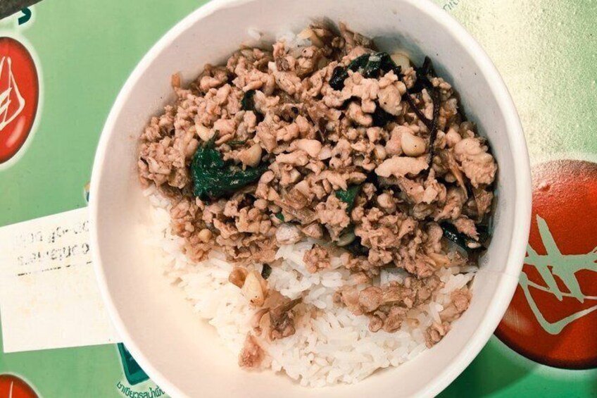 A bowl of rice topped with minced meat and green vegetables. 3