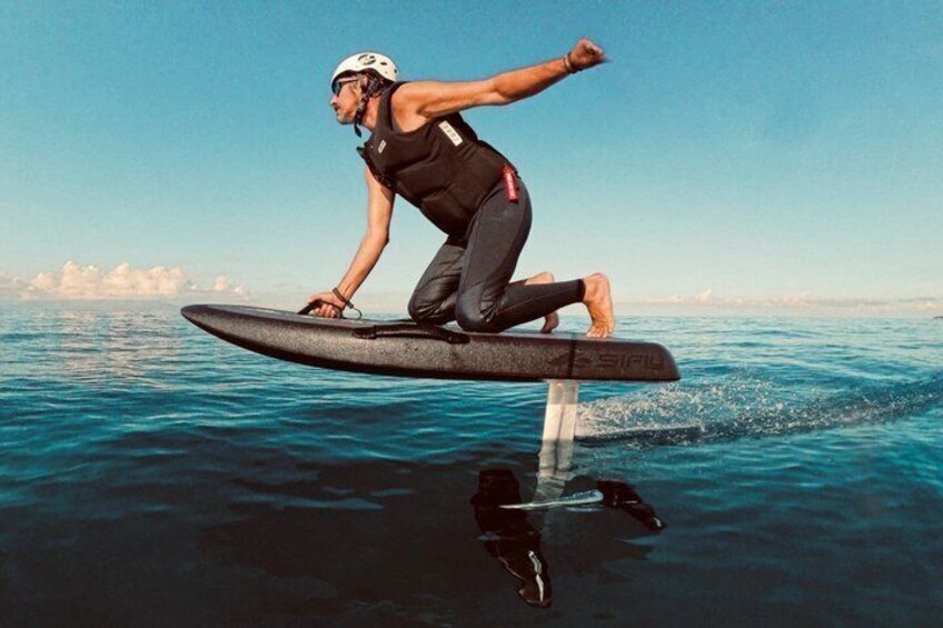 A person riding a hydrofoil board over water. 3