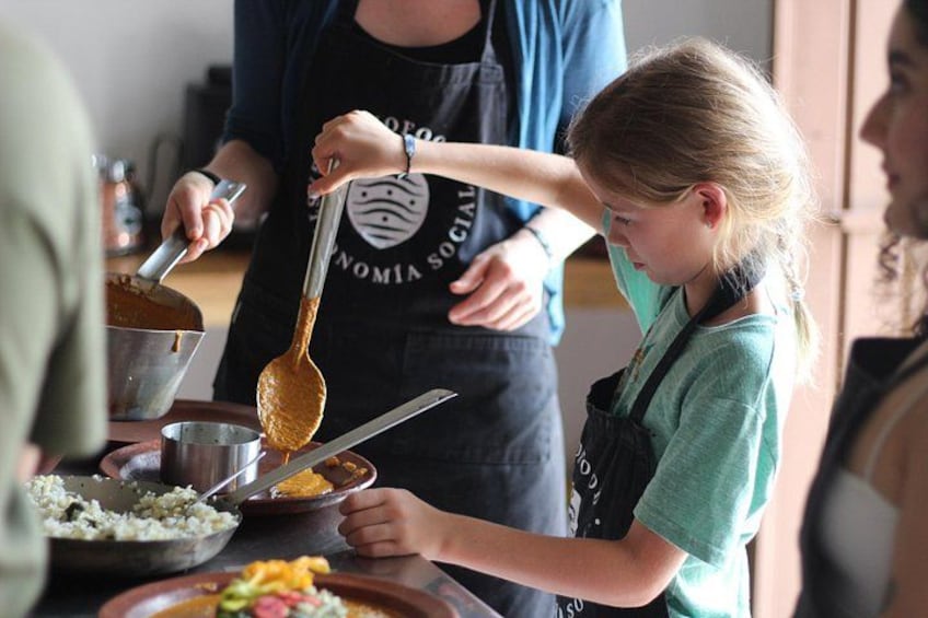 A person cooking with a ladle and a bowl on a stove. 3