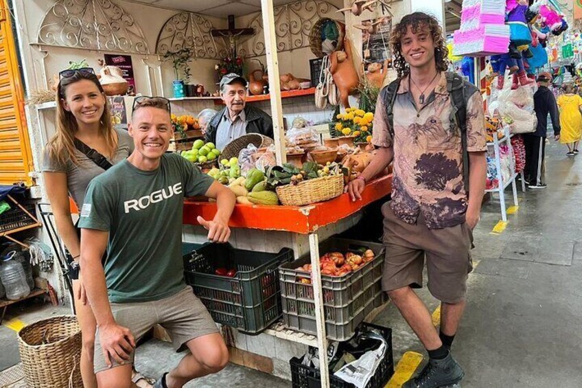 A market stall with fresh produce and a person wearing a 'ROGUE' t-shirt. 5