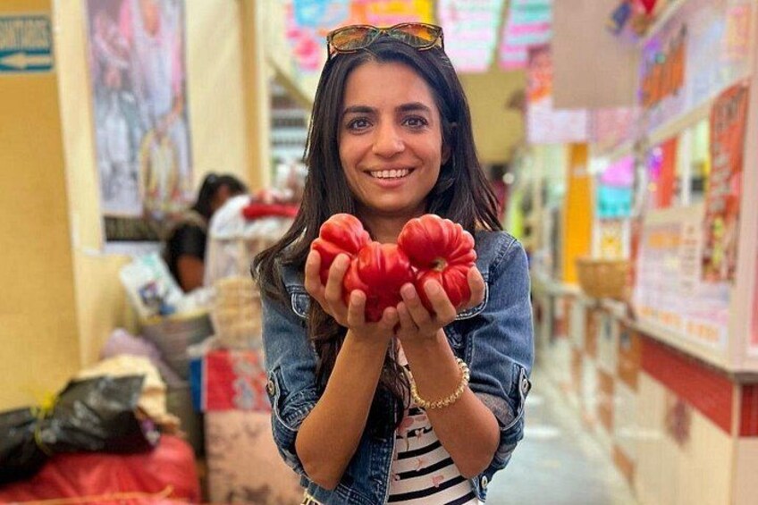 A person holding red objects in a market. 4