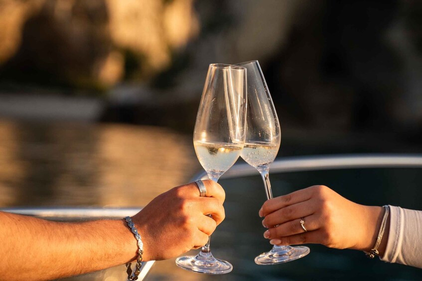 Two people toasting with champagne glasses on a boat. 2