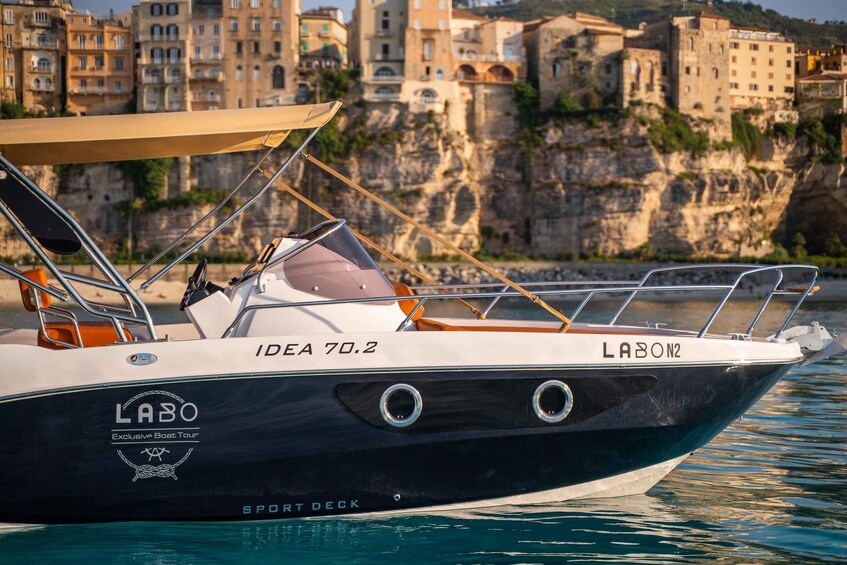 A LABO SPORT DECK boat docked at a marina with a backdrop of historic buildings and cliffs. 3