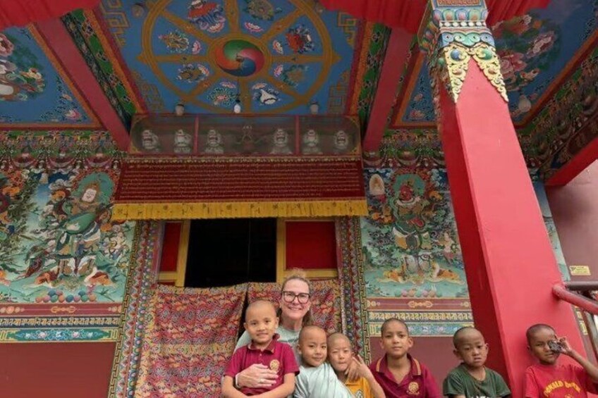 A group of people in front of a colorful, intricately decorated building with traditional architecture. 2