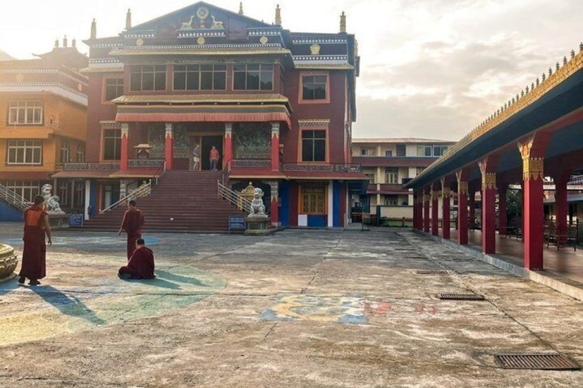 A traditional building with a red facade, a staircase leading to the entrance, and a covered walkway. 4