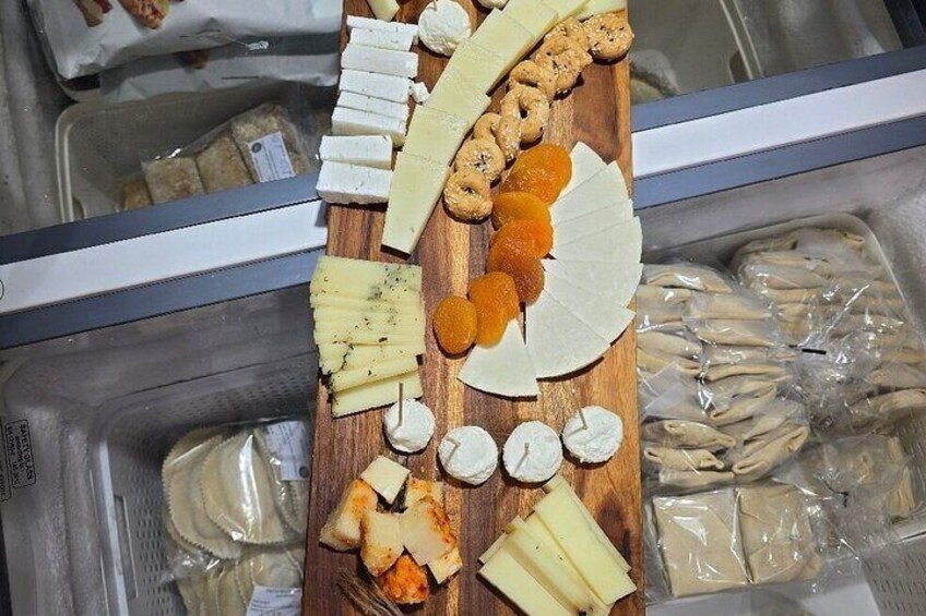 A variety of cheeses and dried fruits on a wooden board. 2