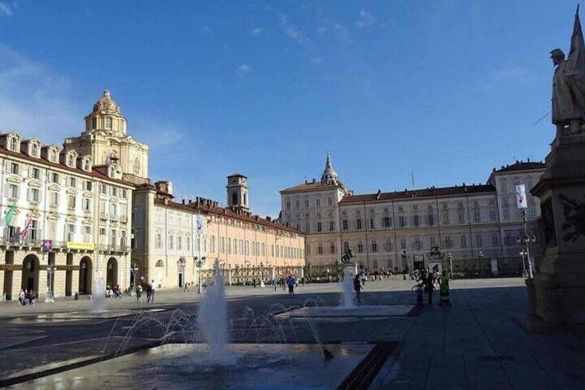 A public square with fountains, historic buildings, and a statue. 5