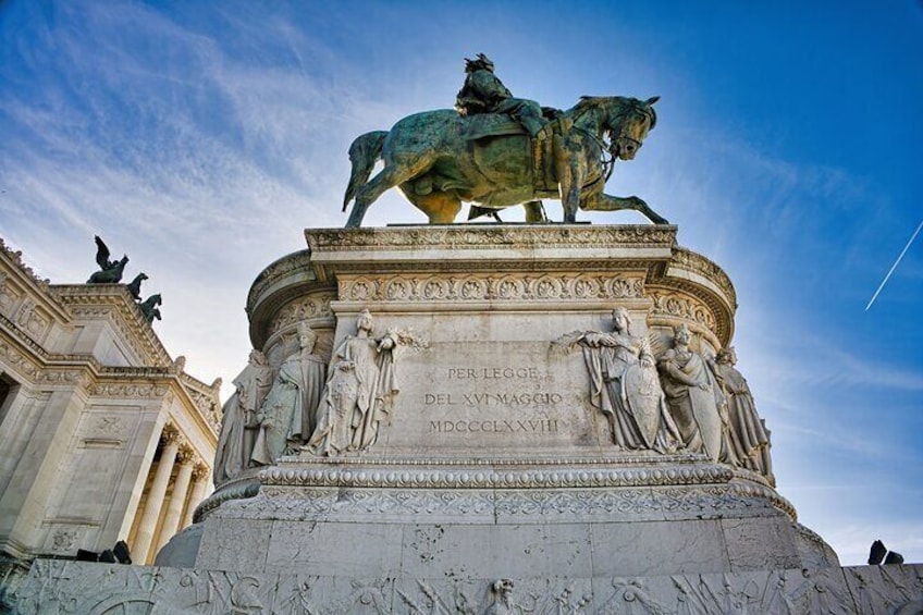 A historical monument with a horse statue, inscriptions, and classical architectural elements. 4