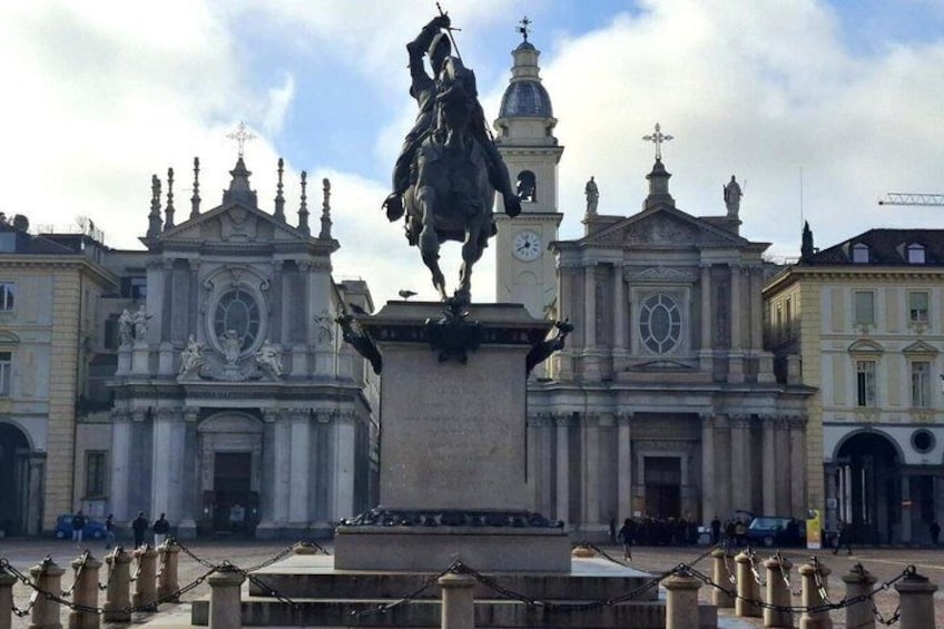 A statue of a man on horseback in front of a large ornate building with a clock tower. 2