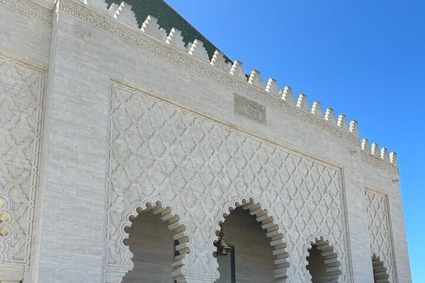 A large white building with intricate carvings and a pointed roof. 3